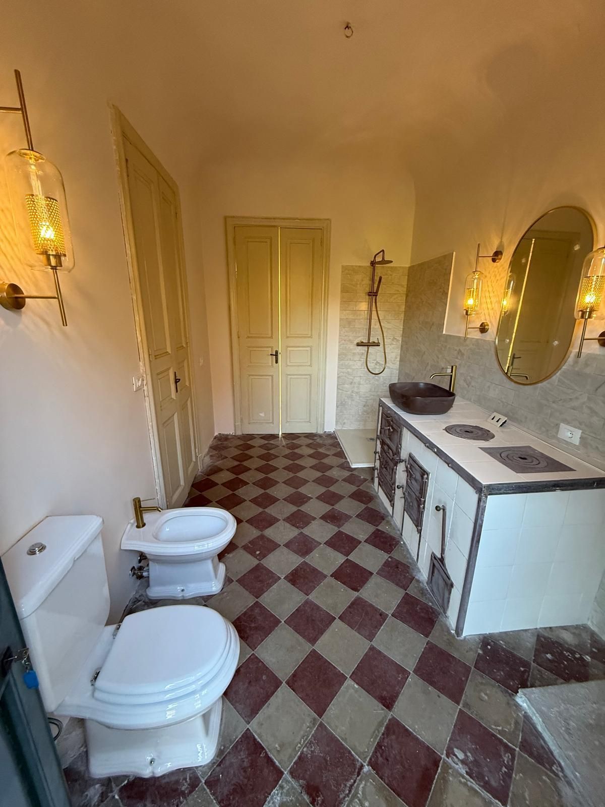 Edificio giallo con finiture e balconi bianchi. Finestre e porte fiancheggiano la facciata.