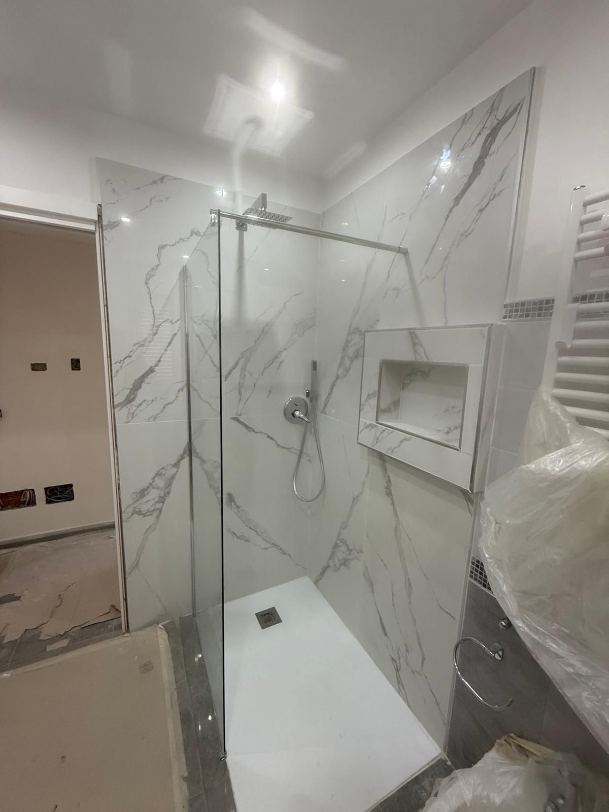 Una piattaforma aerea rossa e bianca con un braccio esteso, posizionata su una strada accanto a un edificio.