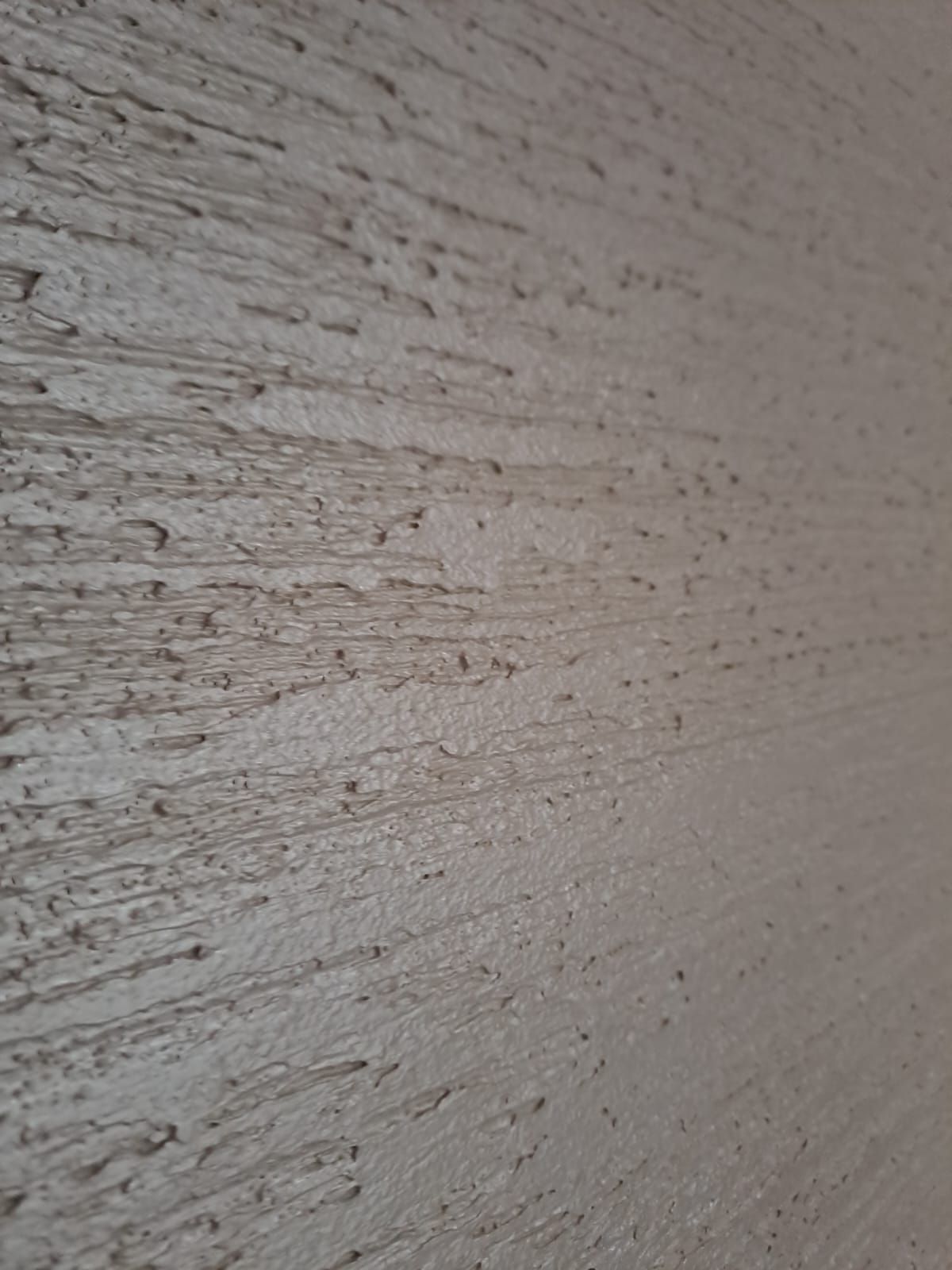 Superficie della parete strutturata con scanalature orizzontali di colore marrone chiaro.