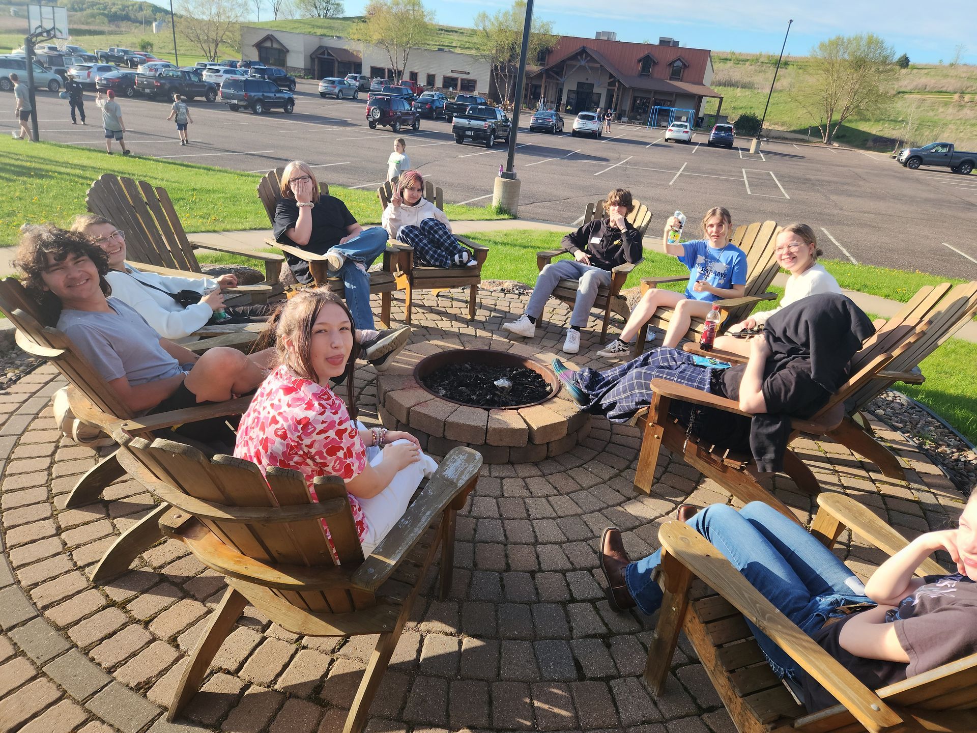 A group of people are sitting around a fire pit.