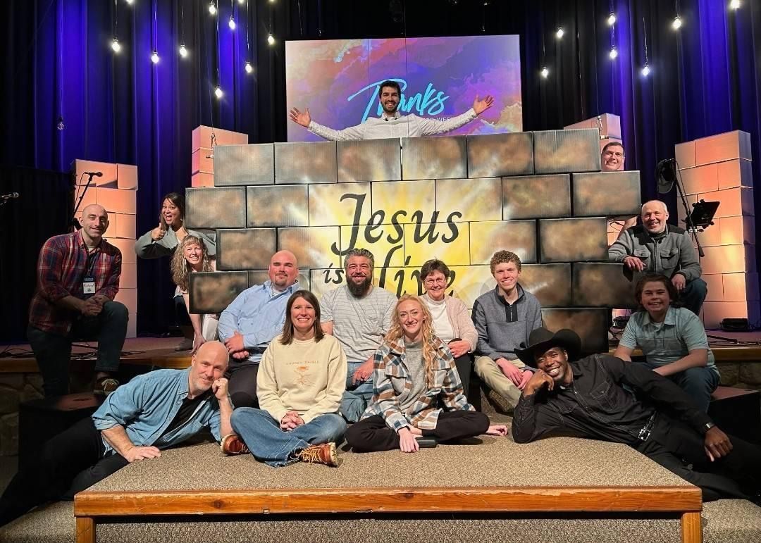 A group of people are posing for a picture in front of a brick wall.