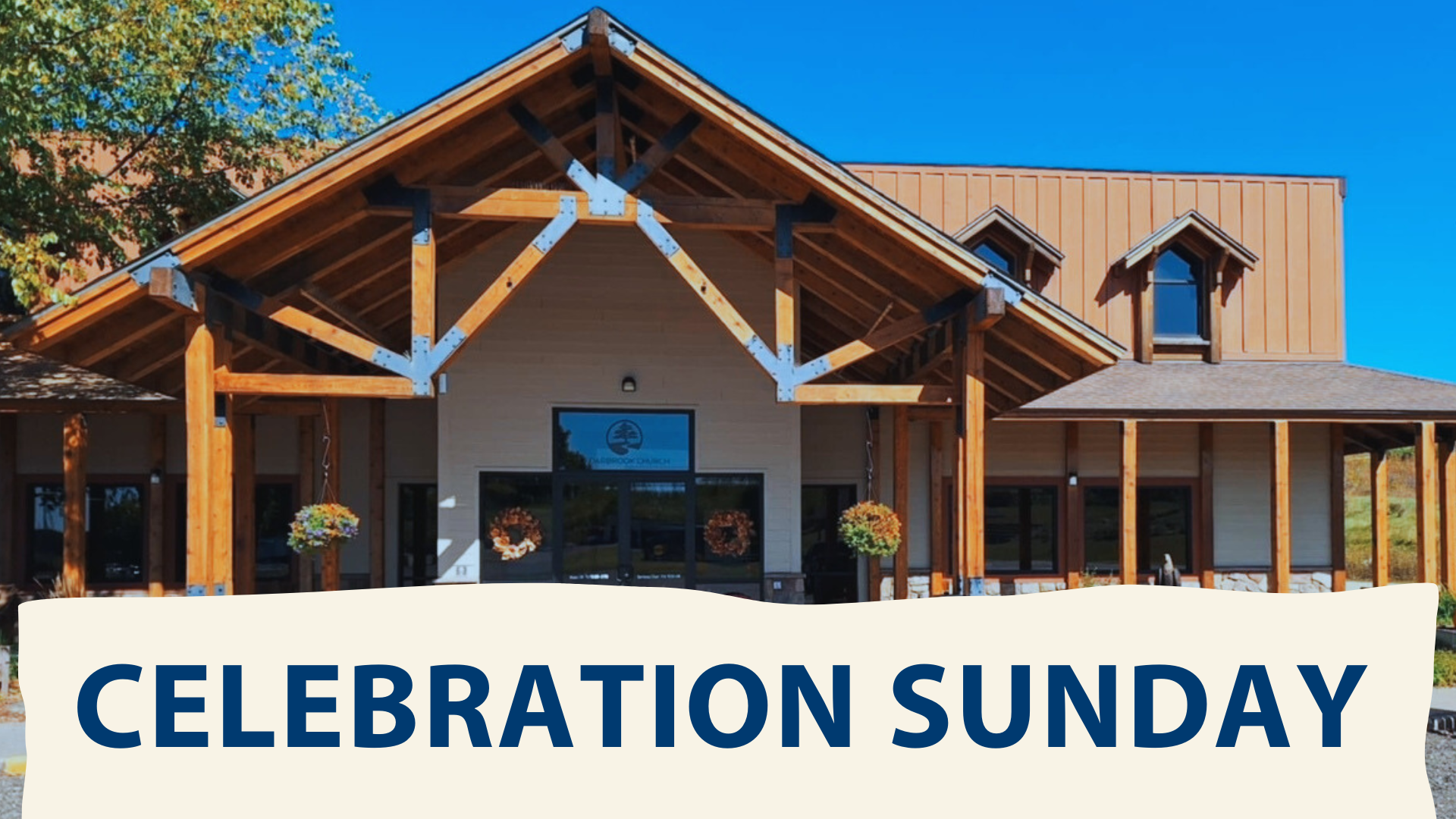 A large wooden building with a sign that says celebration sunday.