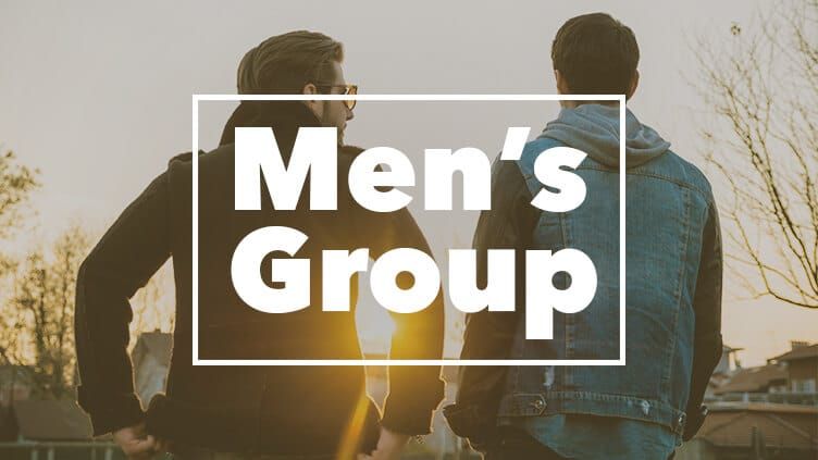 Two men are standing next to each other in front of a sign that says men 's group.