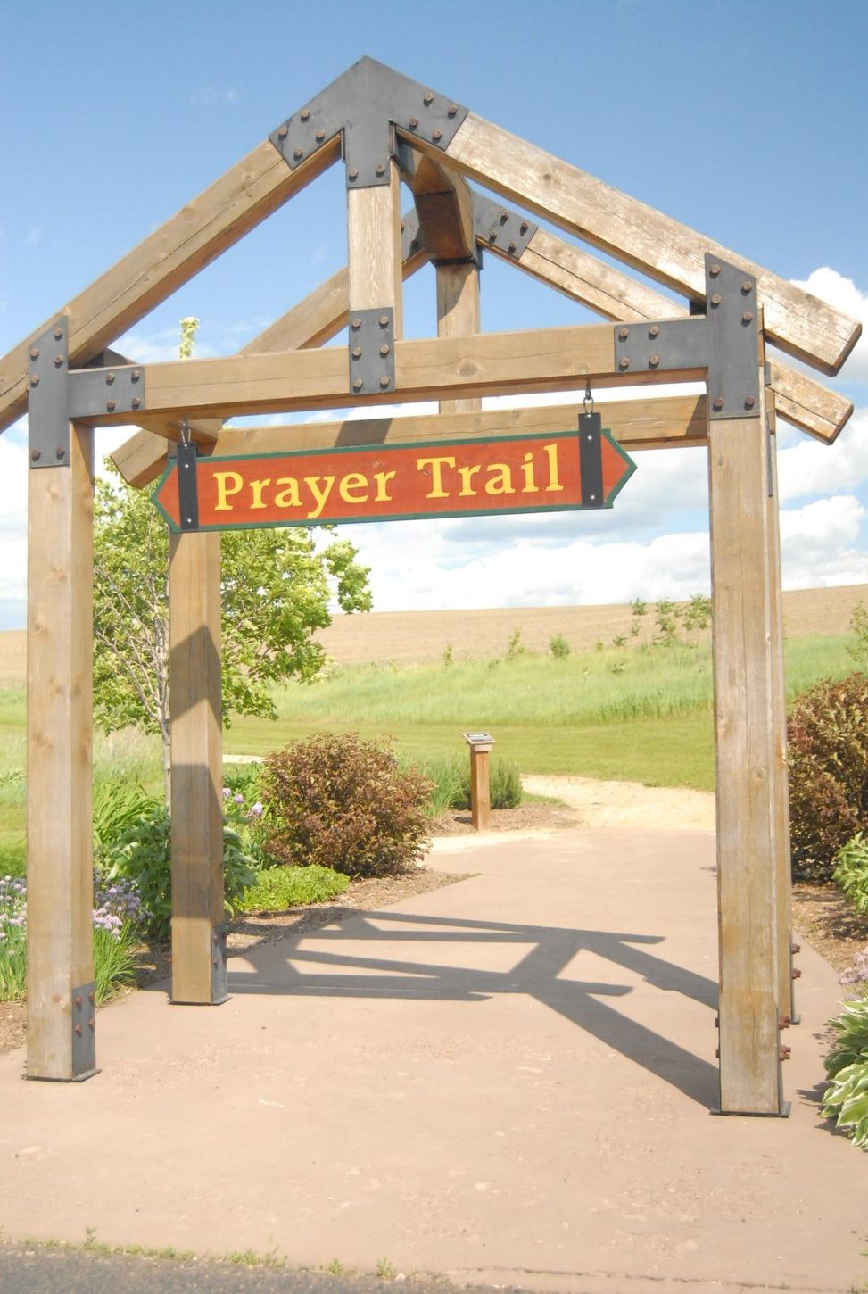 A wooden archway with a sign that says prayer trail