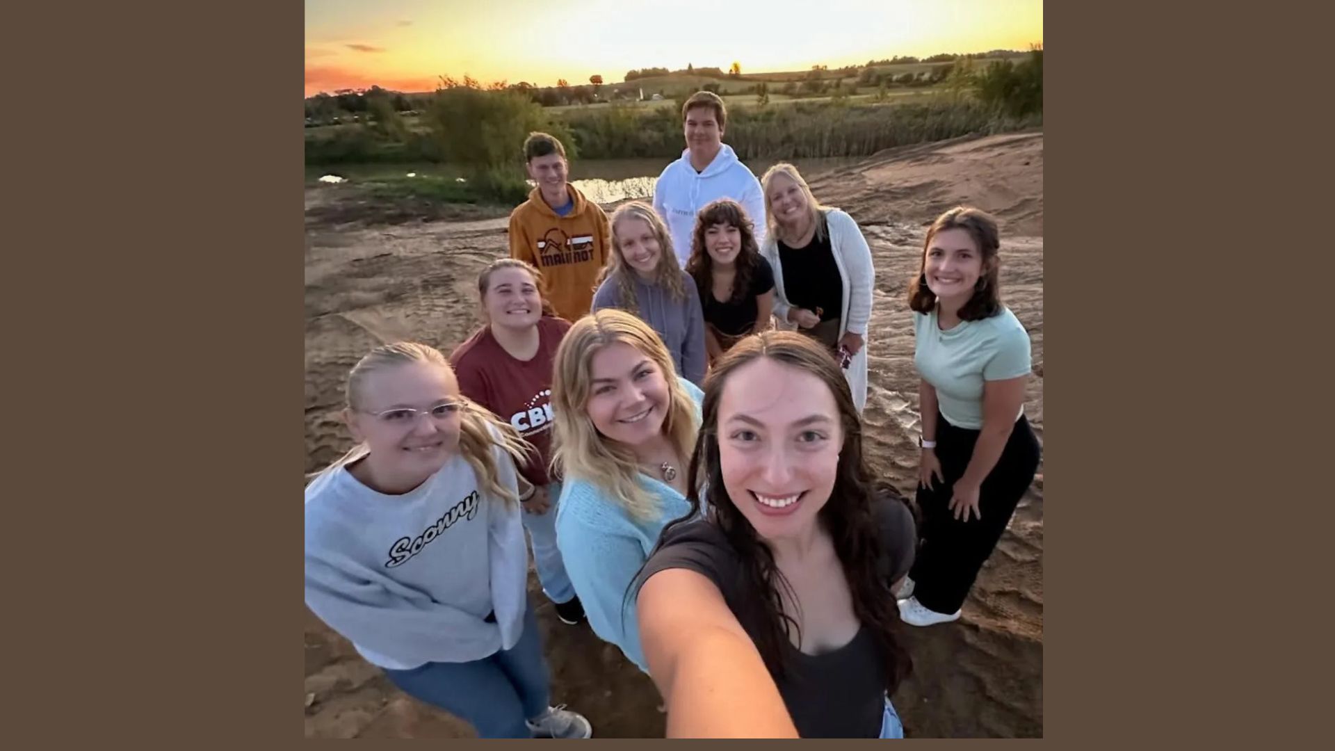 A group of people posing for a picture with one woman wearing a shirt that says cb