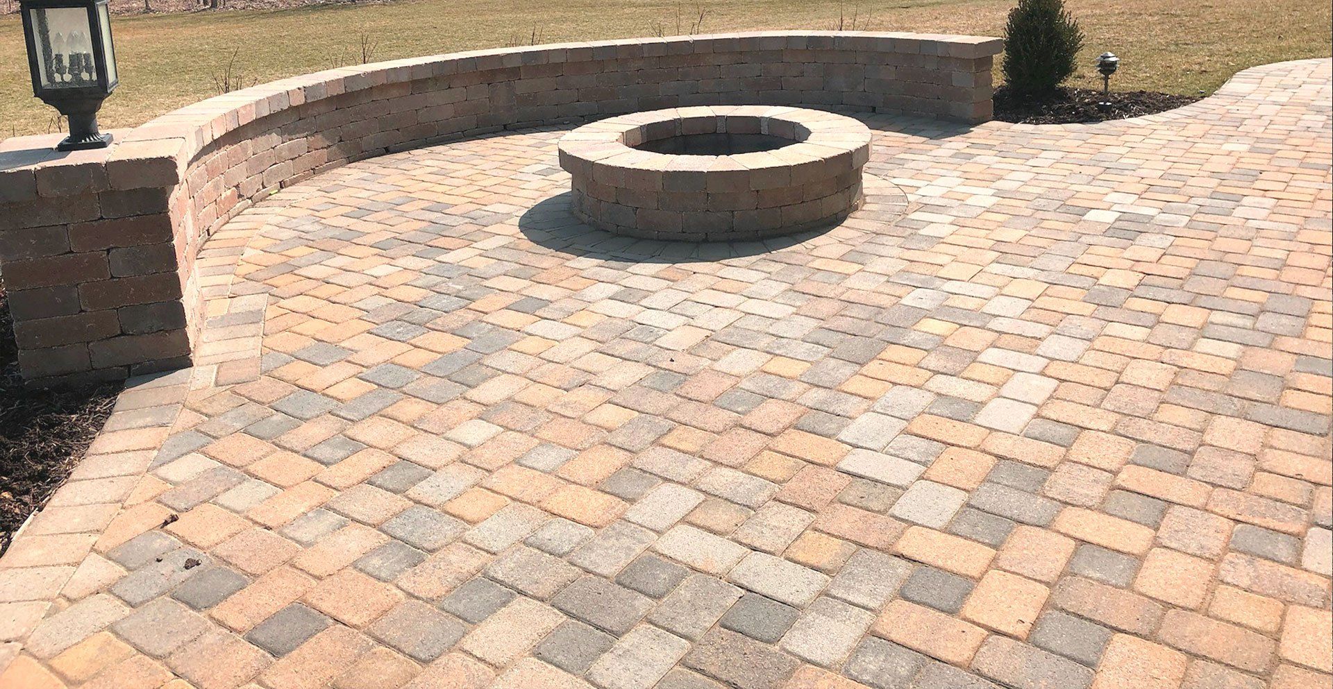 A fire pit is sitting on top of a brick patio.