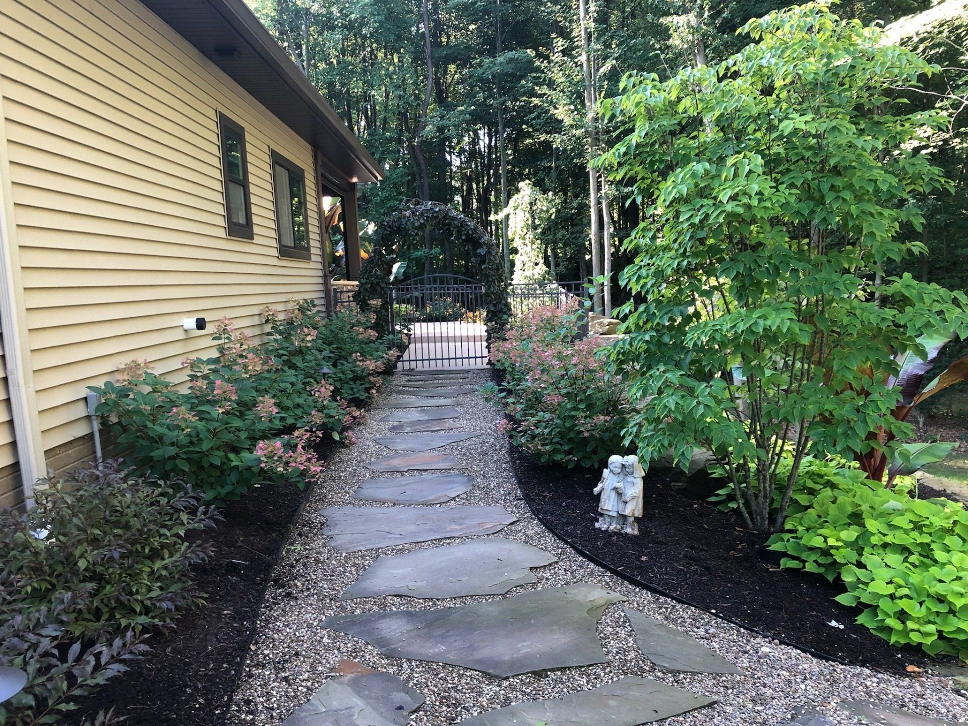 A stone walkway leading to a house in the woods