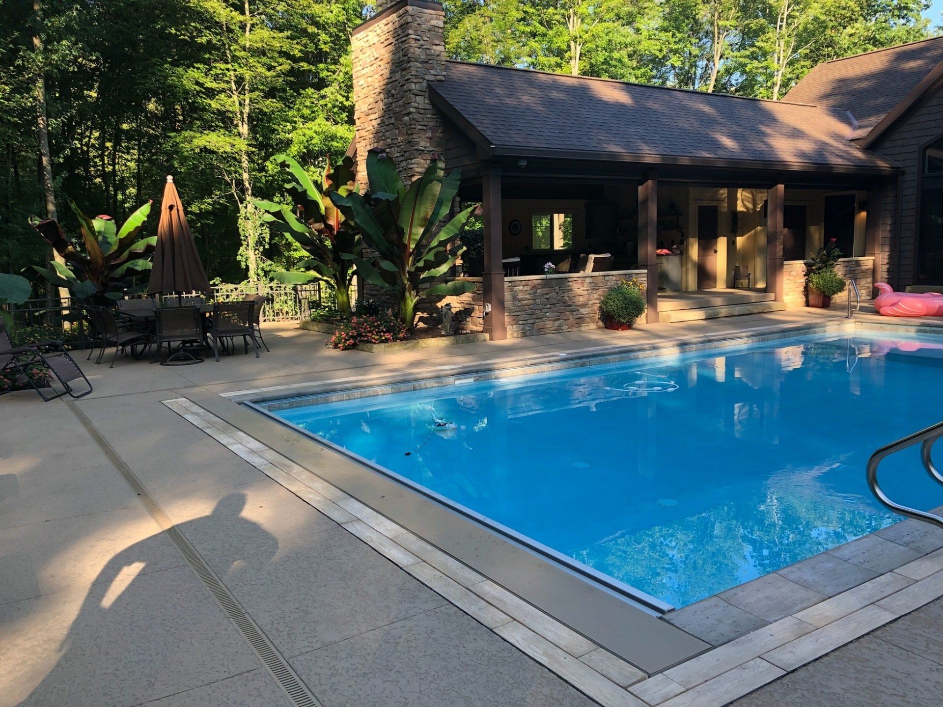 A large swimming pool with a house in the background