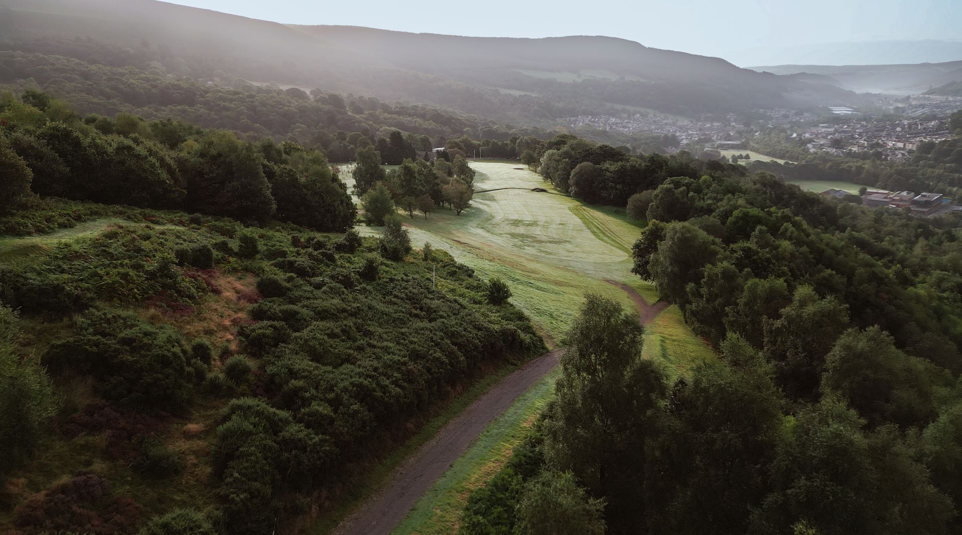 An aerial view of a road going through a forest.