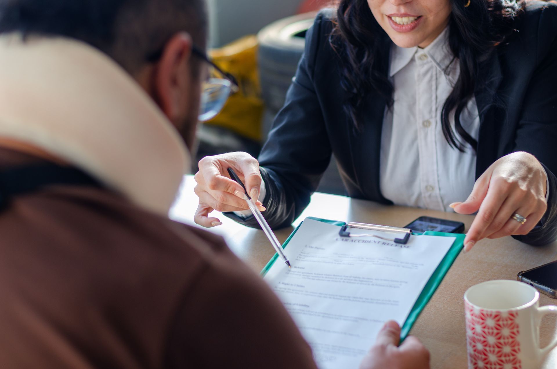 A lawyer showing a document paper to a client. A lawyer showing a document paper to a client.