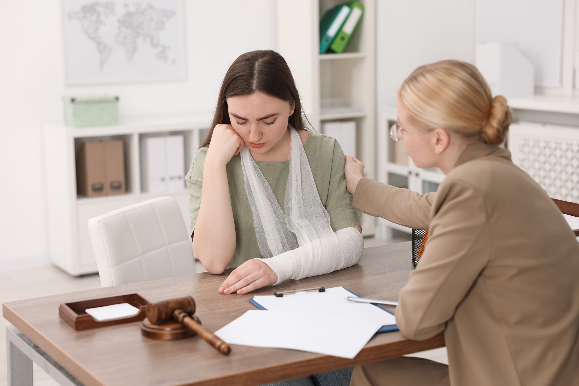 An injured woman meets with a lawyer in the office for a legal consultation.