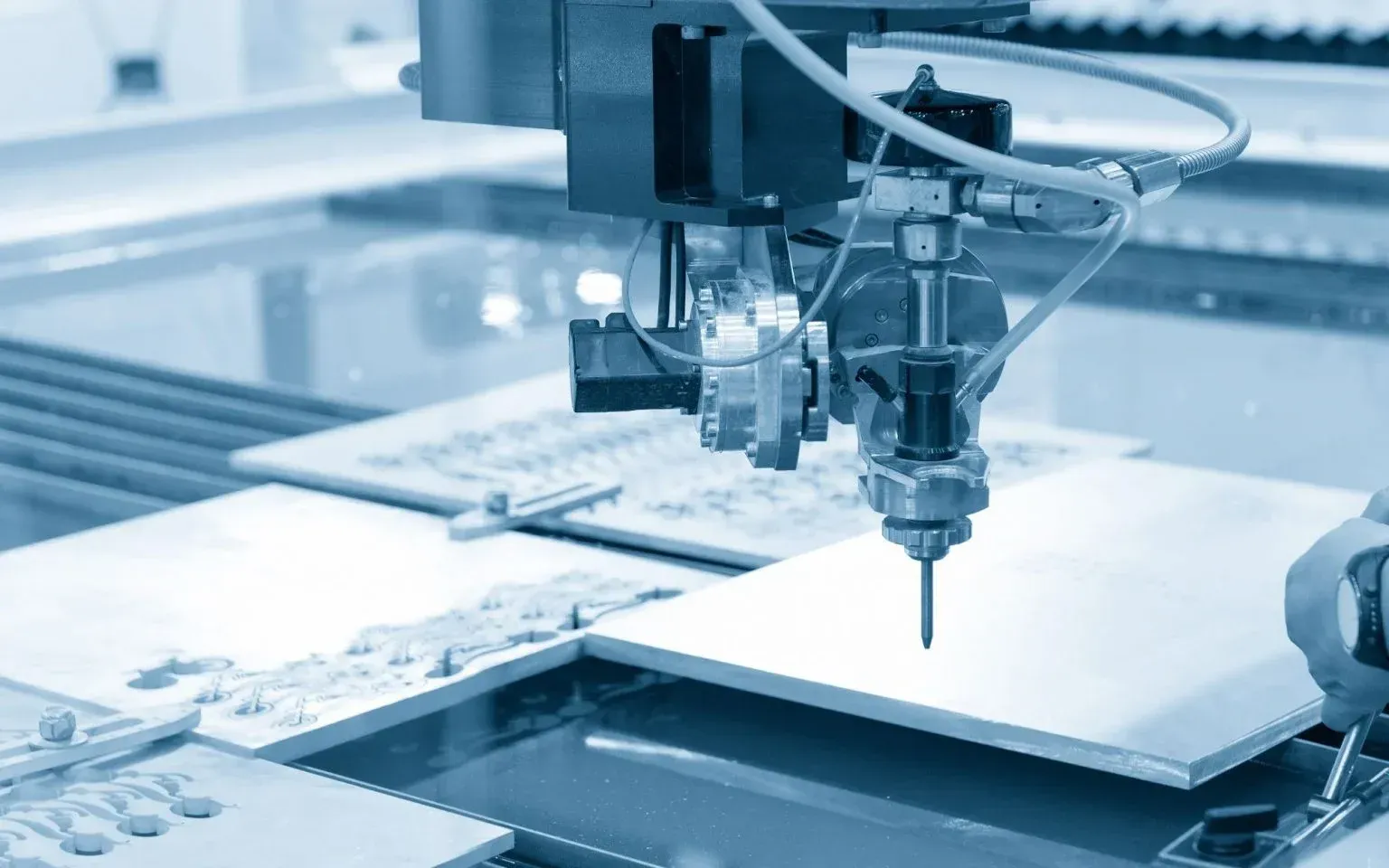 A machine is cutting a piece of glass with water.