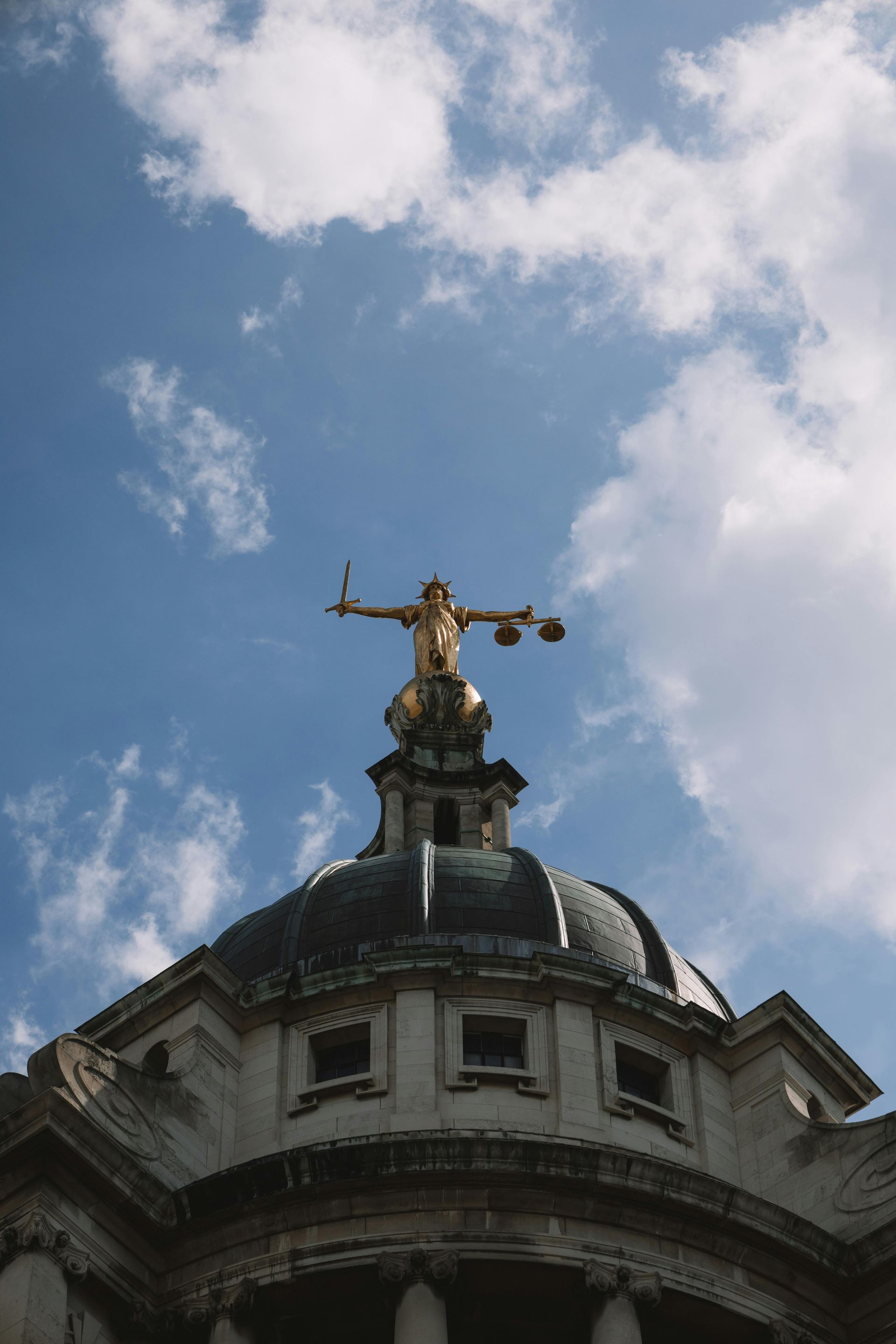 A statue of justice is on top of a building.