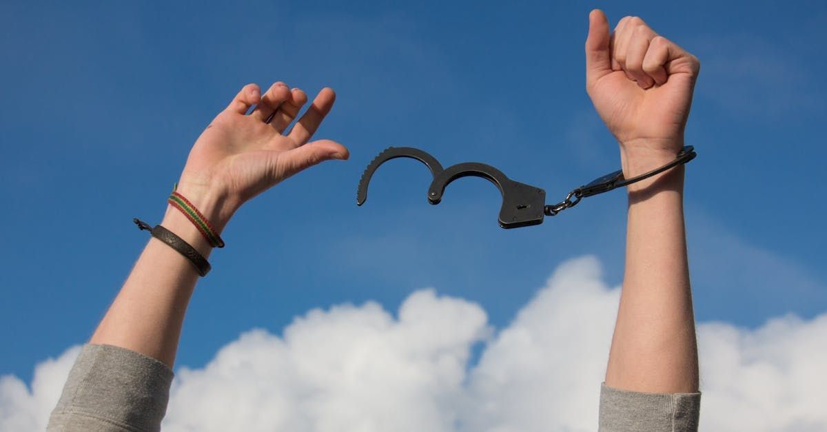 A person is holding a pair of handcuffs in their hands.