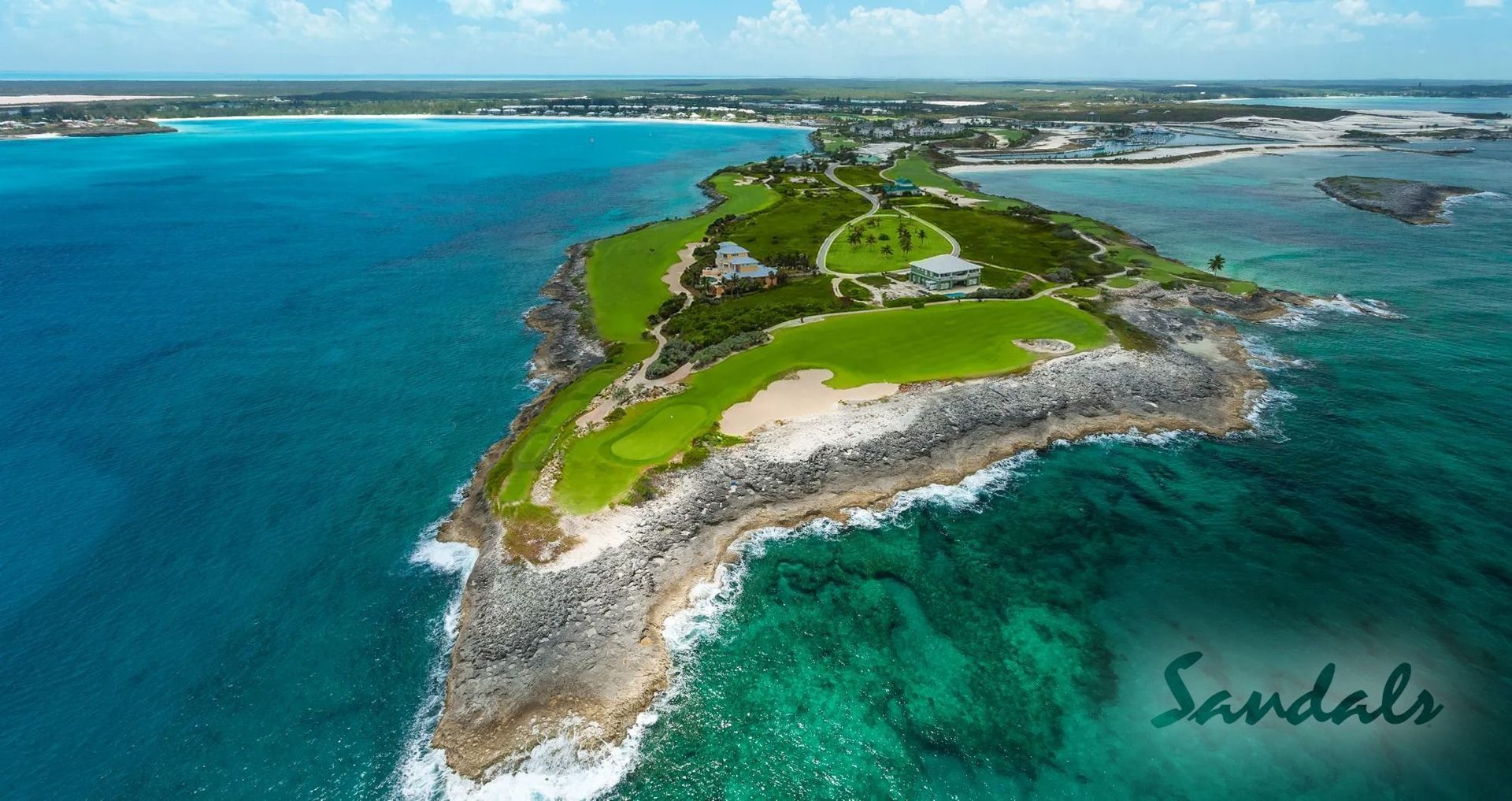 Dramatic aerial view of fairways that line the sea cliffs at Sandals Emerald Bay Golf Course.