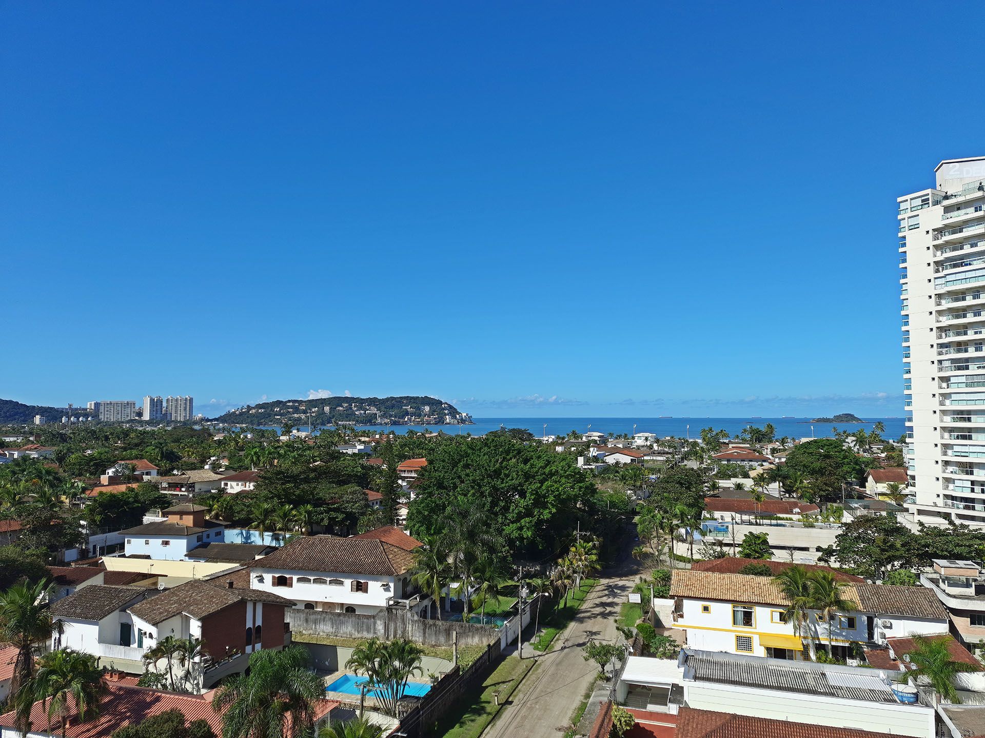 Uma vista aérea de uma cidade com um edifício alto ao fundo.