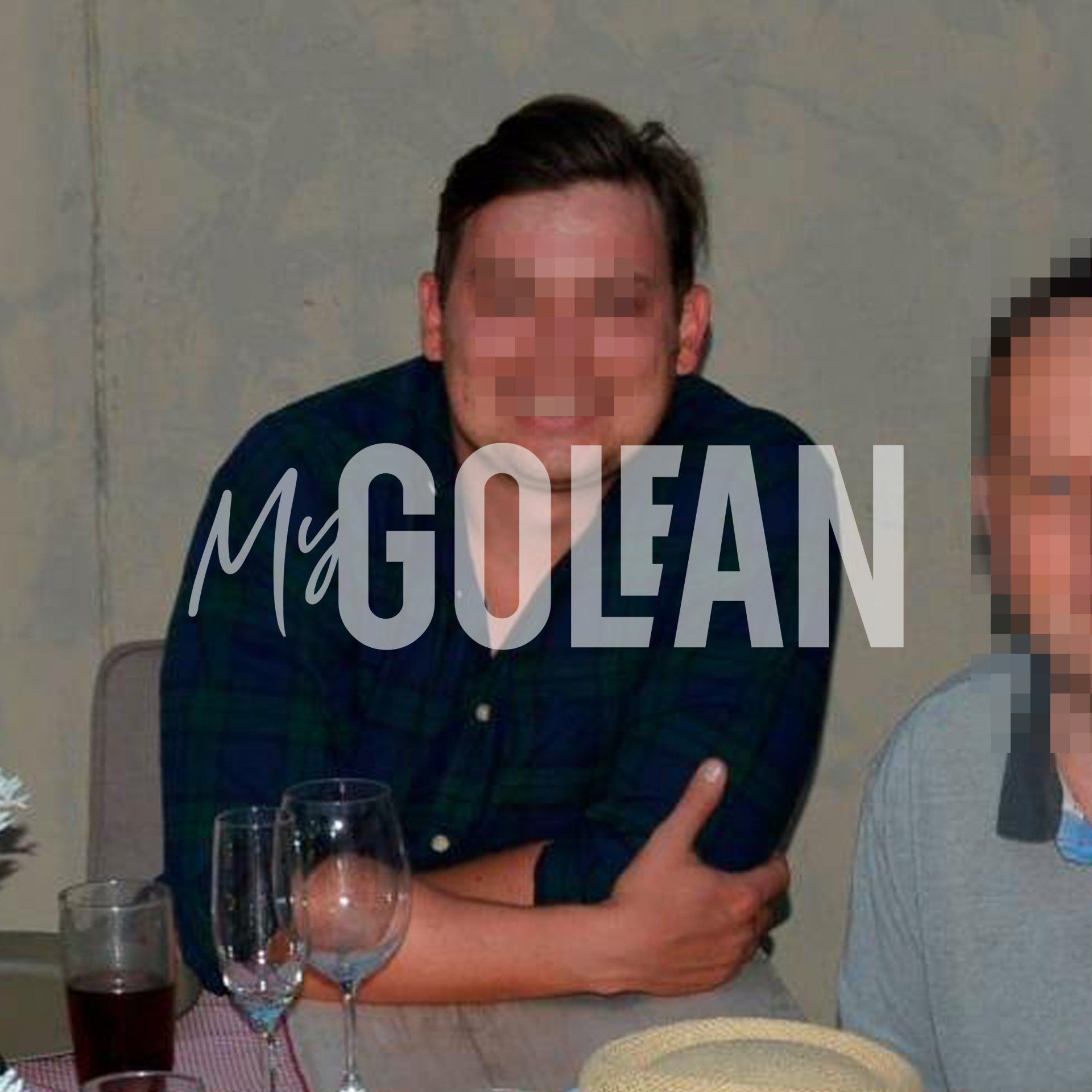 A man in a plaid shirt is sitting at a table with glasses of wine and the name mcgolean behind him