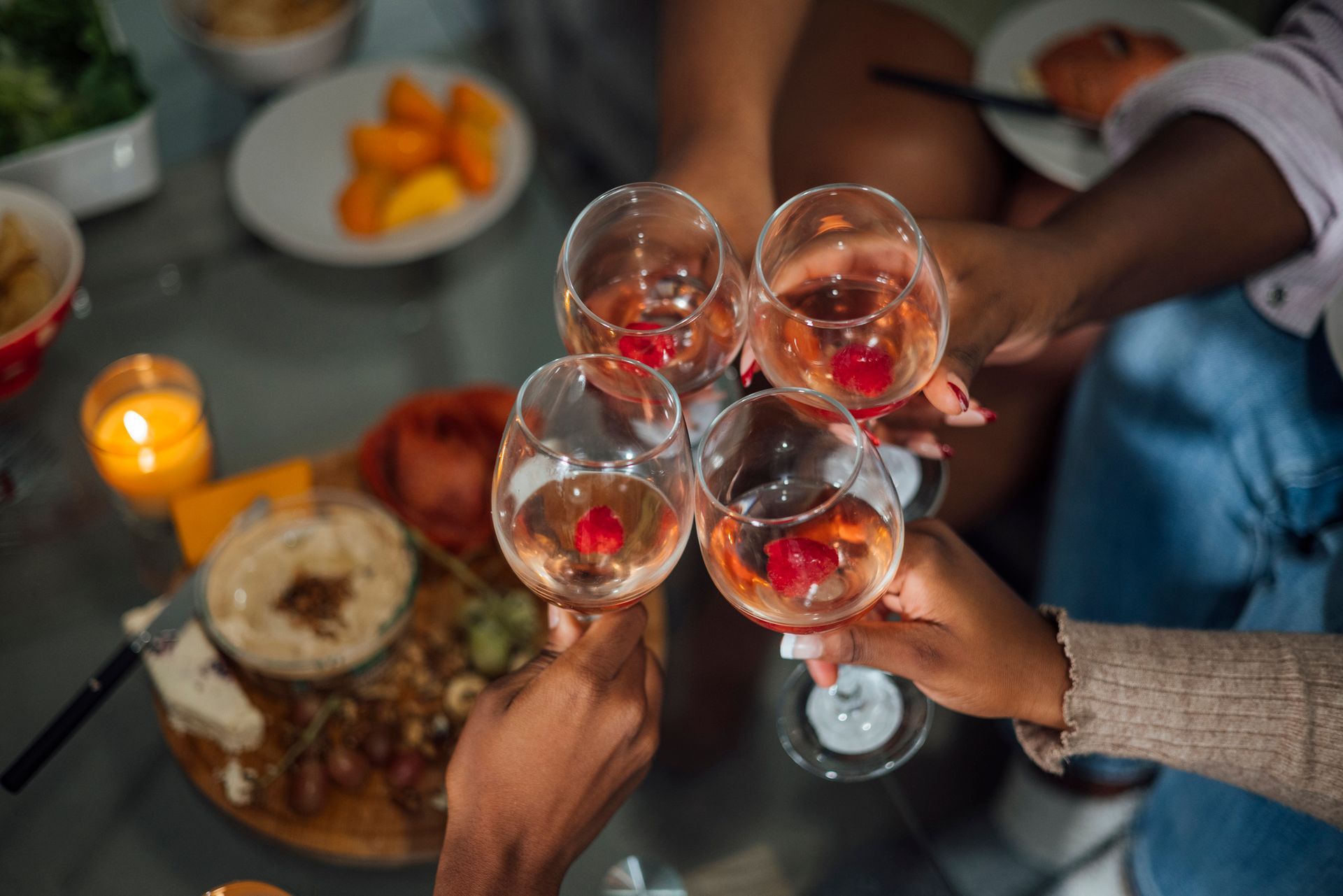 A group of people are toasting with wine glasses at a table.