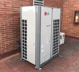 Un acondicionador de aire LG está ubicado frente a una pared de ladrillos.