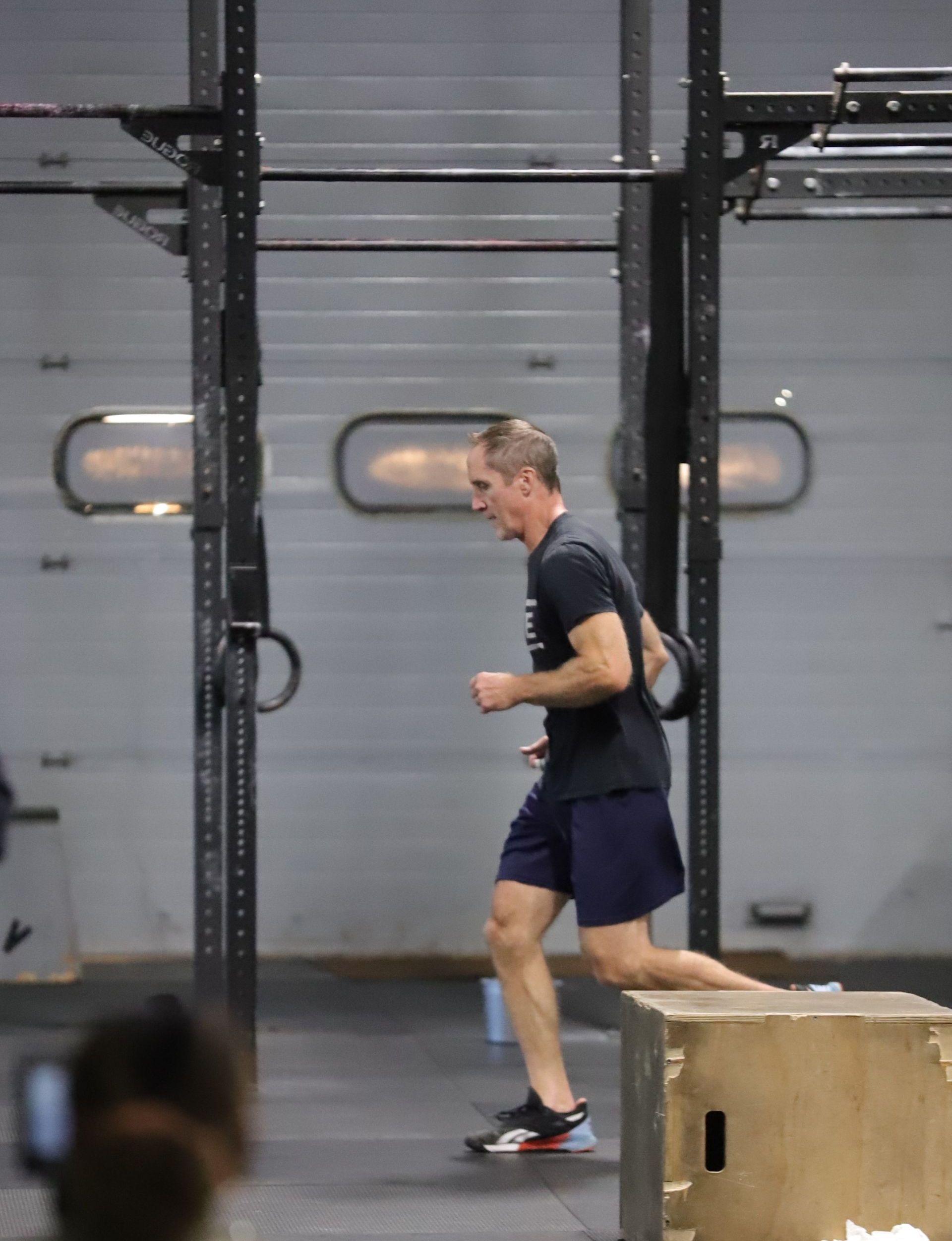 A man runs across the gym floor