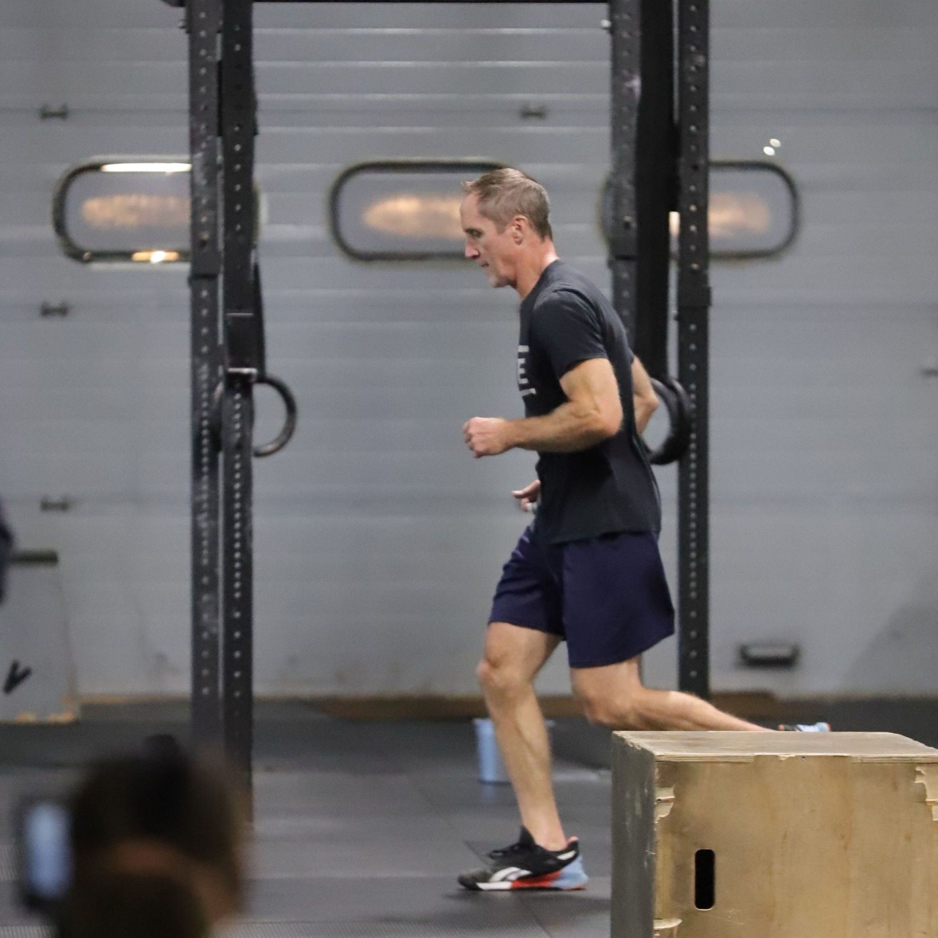 A man runs across the gym floor.