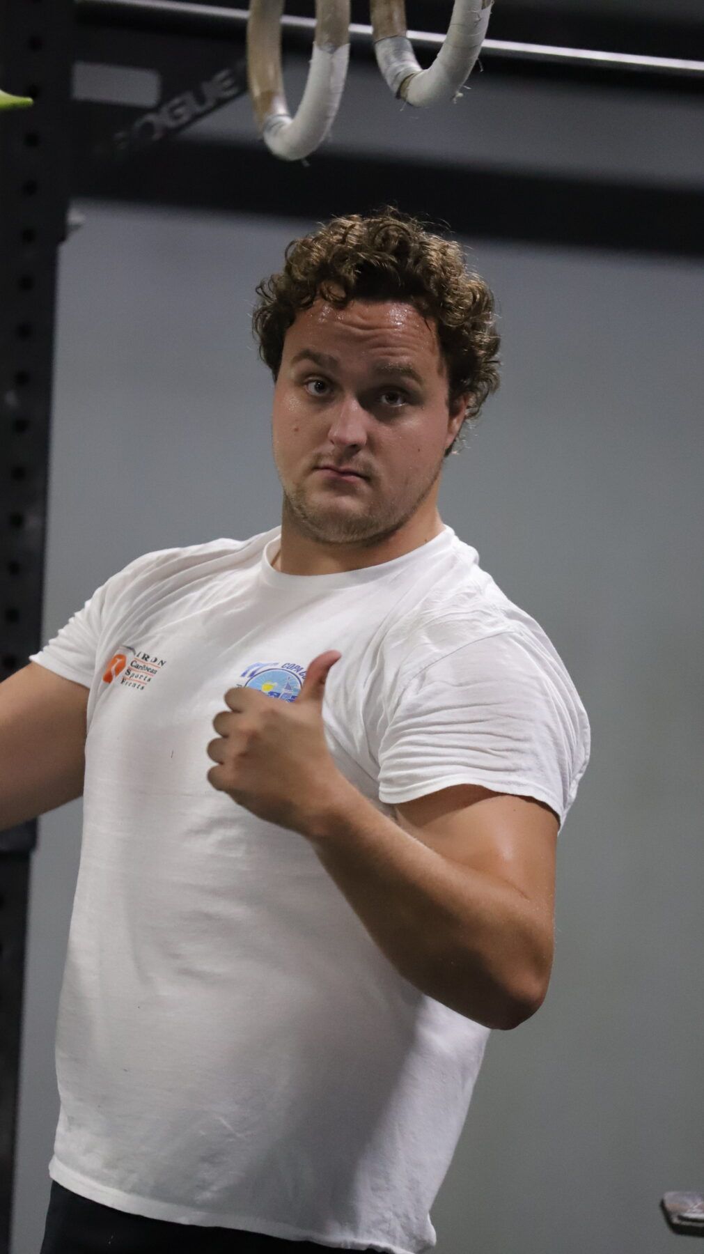 A man in a white shirt is giving a thumbs up at CrossFit Vertex gym in Scranton, PA