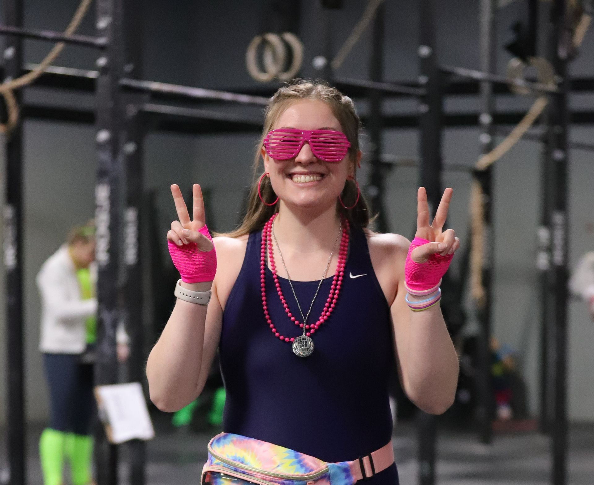 A smiling girl dressed in an 80s outfit ready to workout