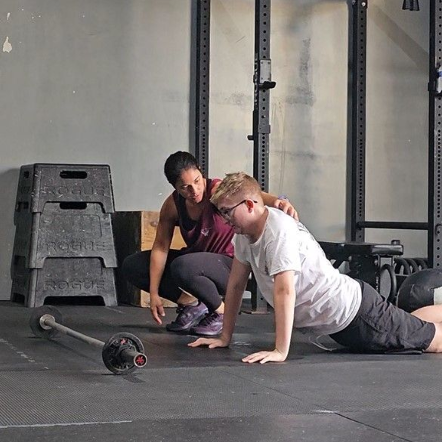 A Coach guides her athlete through the push up.