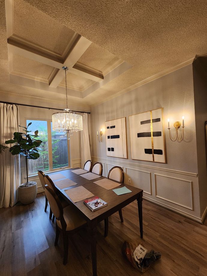 A dining room with a table and chairs and a chandelier.