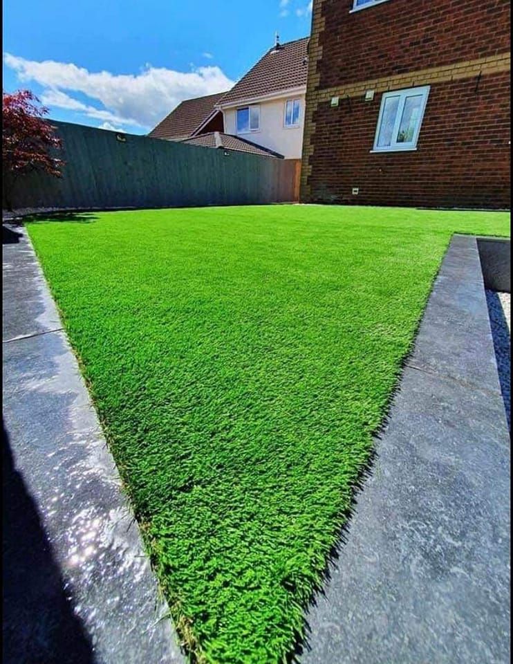 A lush green lawn in front of a brick house.
