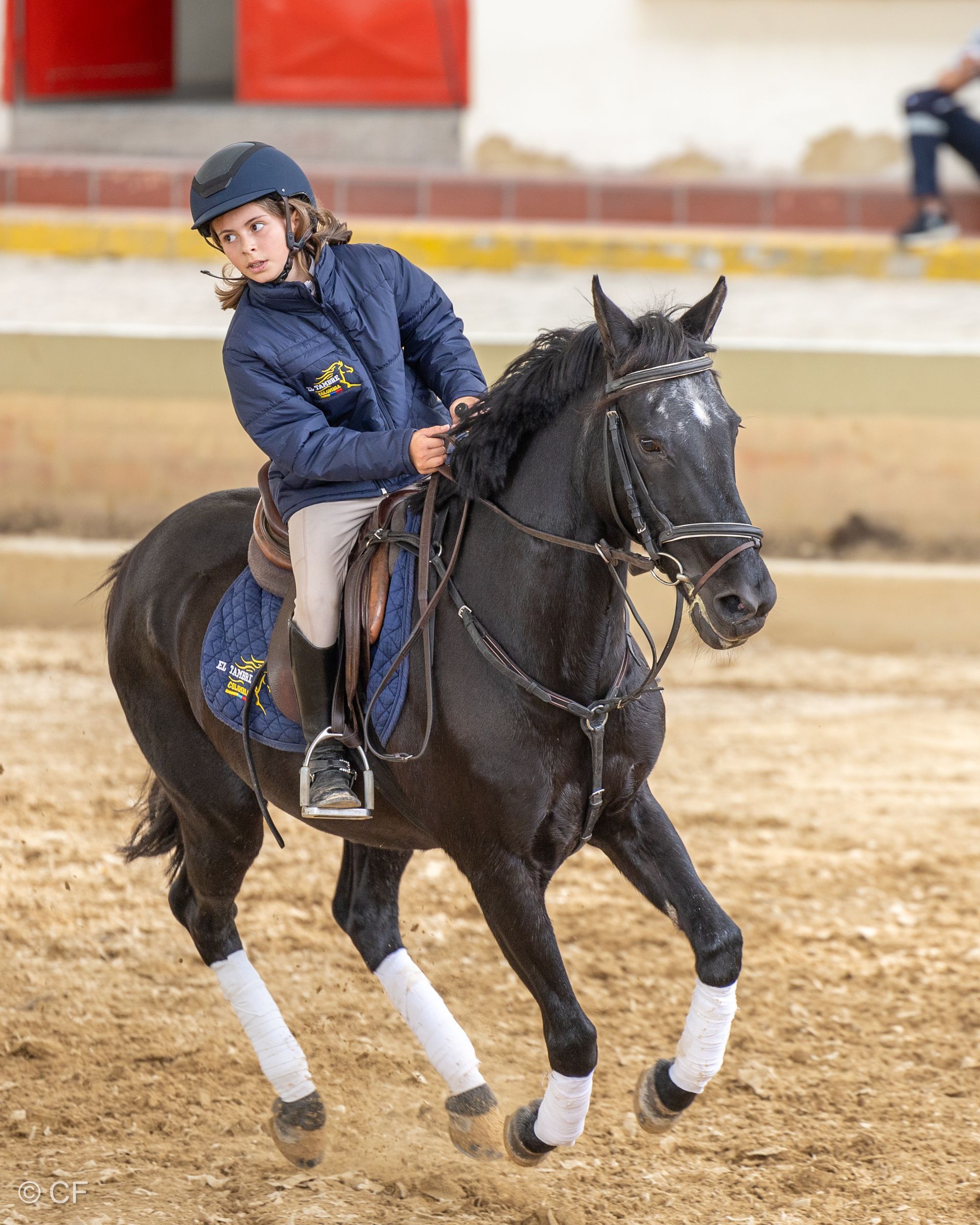 a young girl is riding a black horse