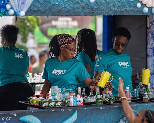 A group of women wearing spirit shirts are working at a bar