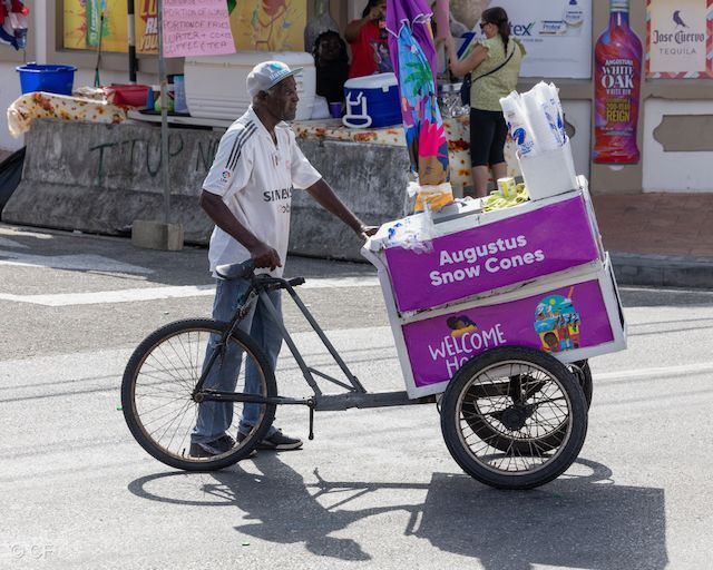 A man is pushing a cart that says augustus snow cones