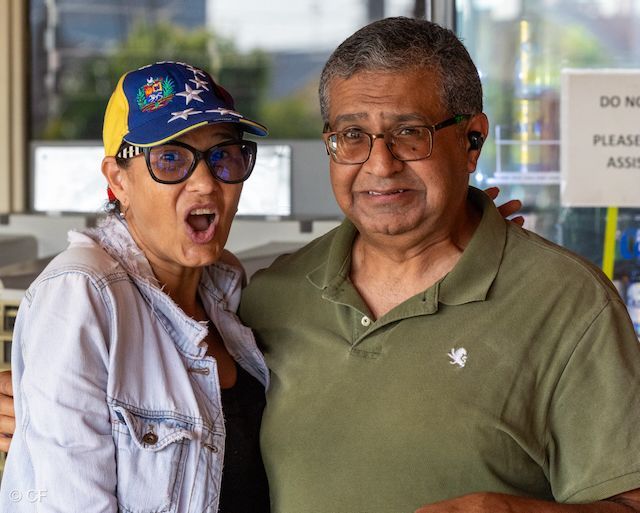 A man and a woman are posing for a picture in a restaurant.