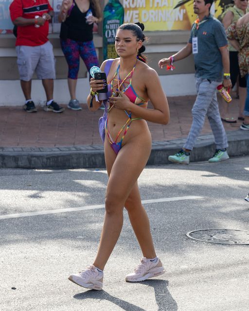 A woman in a bikini is walking down the street