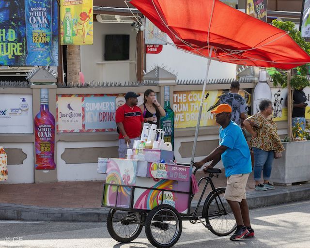 A man is pushing a cart with a sign that says oak on it