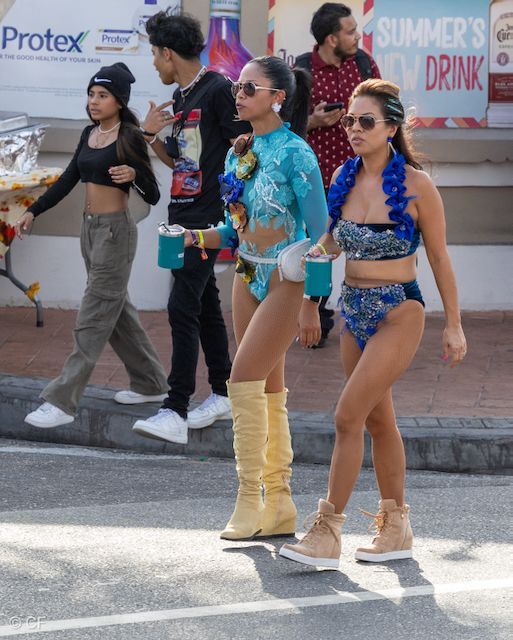 A group of people walking down a street in front of a protex sign