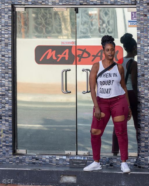 A woman wearing a white tank top that says when in doubt sanat