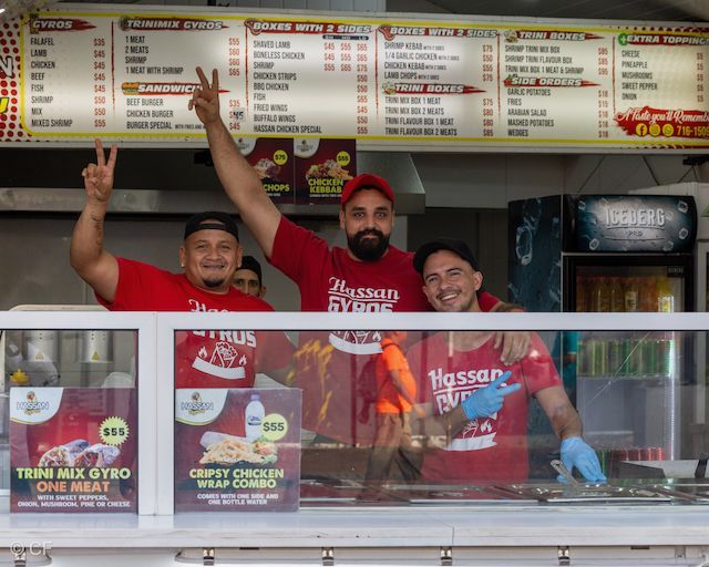 A group of men standing behind a counter at a fast food restaurant