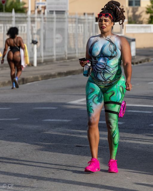 A woman with her body painted is walking down the street
