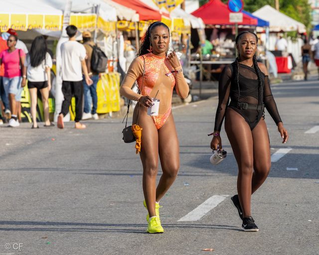 Two women in swimsuits are walking down the street