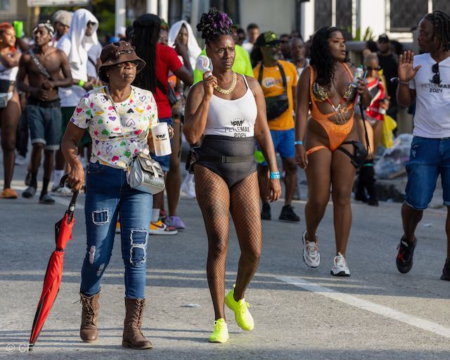 A group of people in swimsuits are walking down a street.