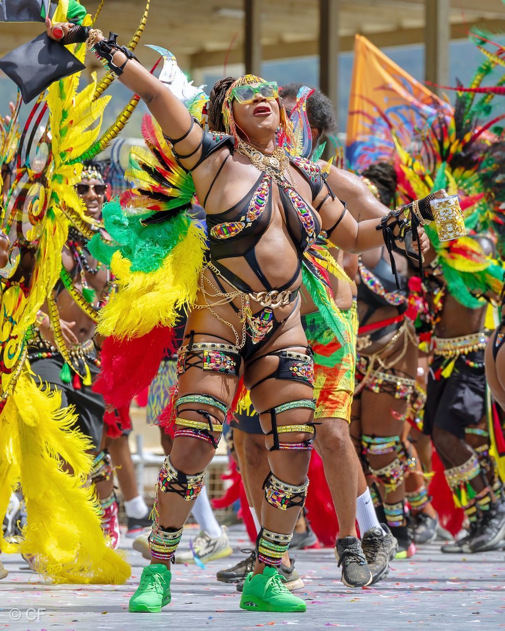 A woman in a colorful costume is dancing in a parade.