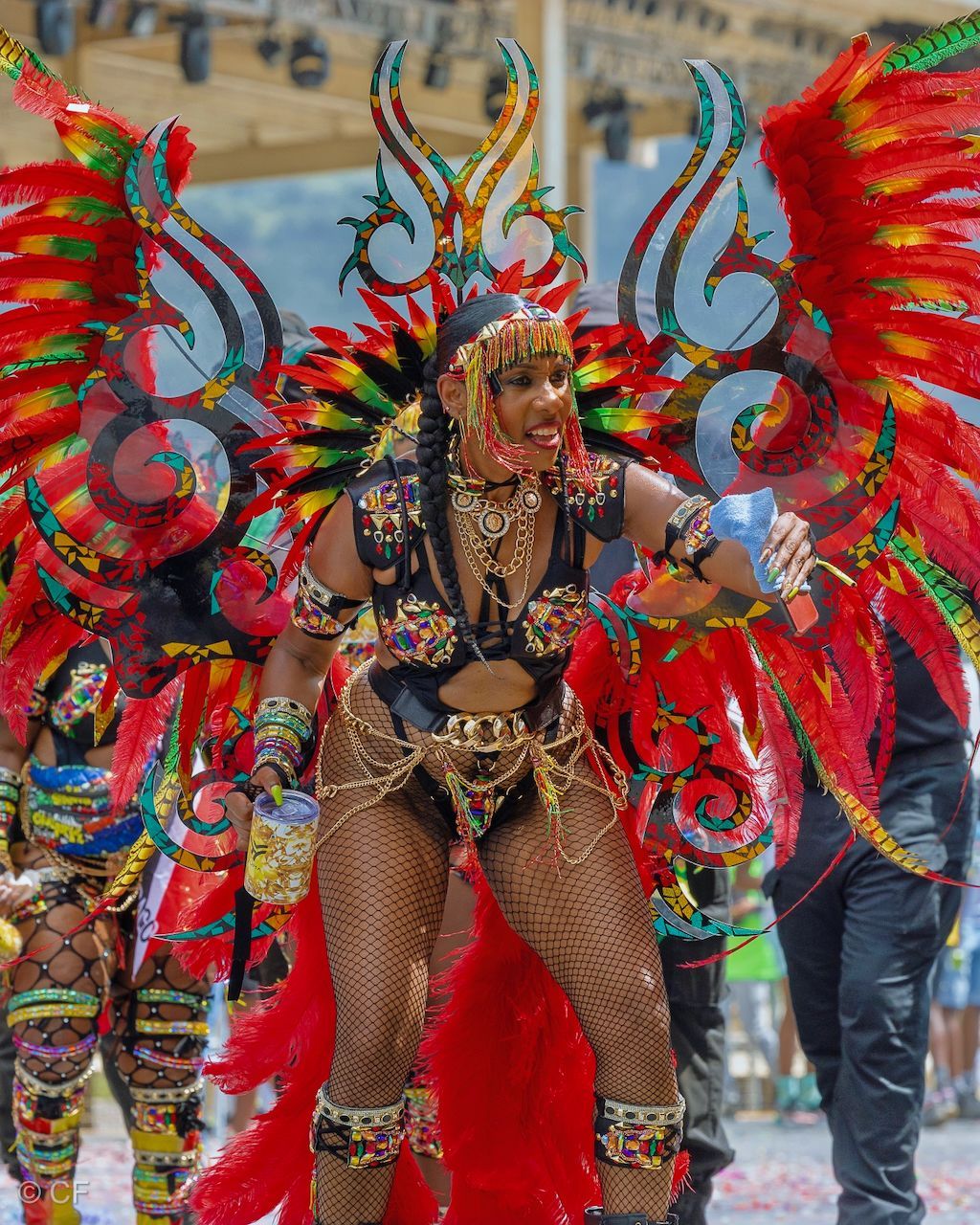 A woman in a colorful costume is dancing in a parade.