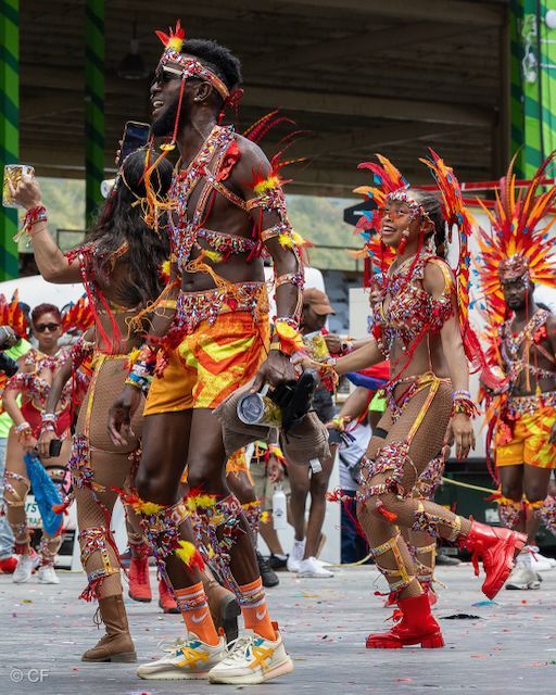 A group of people in colorful costumes are dancing in a parade.