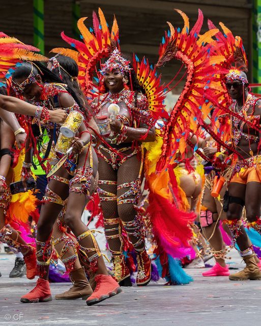 A group of people in colorful costumes are dancing in a parade.