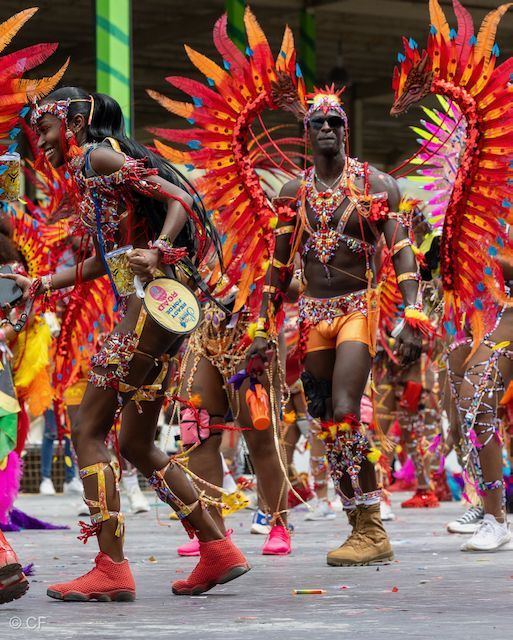 A group of people in colorful costumes are walking down a street.