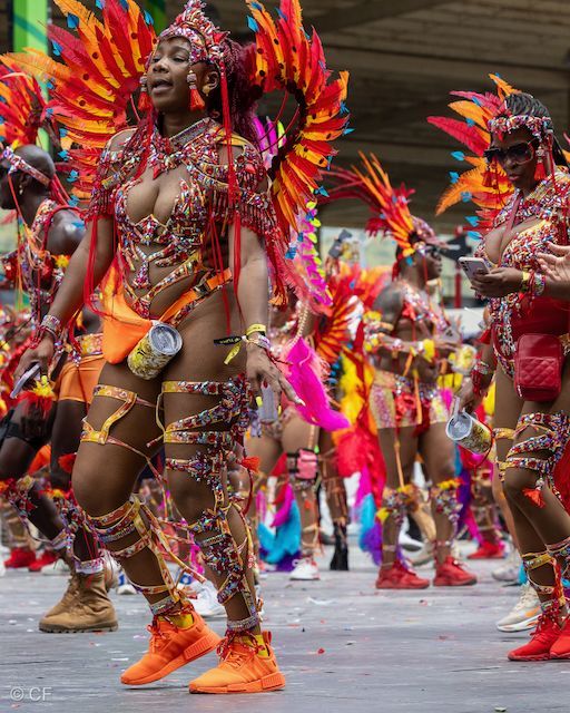 A group of people in colorful costumes are dancing in a parade.