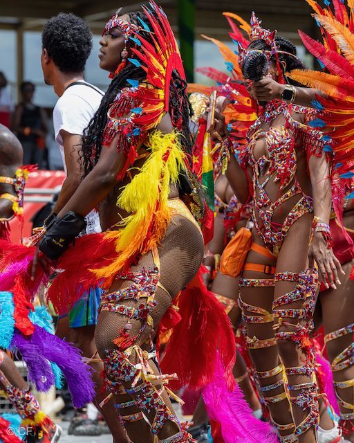 A group of people in colorful costumes are dancing in a parade.