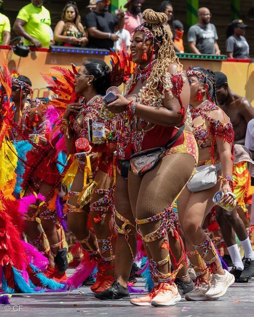 A group of people in colorful costumes are dancing in a parade.